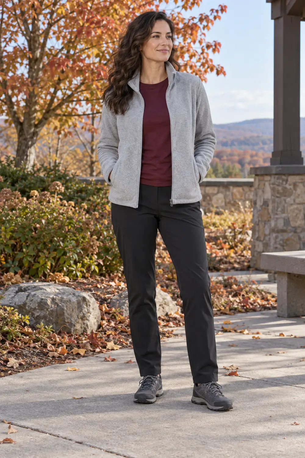 Light-gray zip fleece, burgundy tee, black tapered travel trousers, and dark-gray walking shoes
